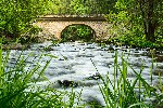 View of the stone bridge Zemská brána and a mountain river in the woods