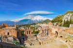 Ruins of Ancient Greek theatre in Taormina on background of Etna Volcano, Italy