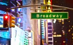Broadway Sign and red stop light in New York City at night